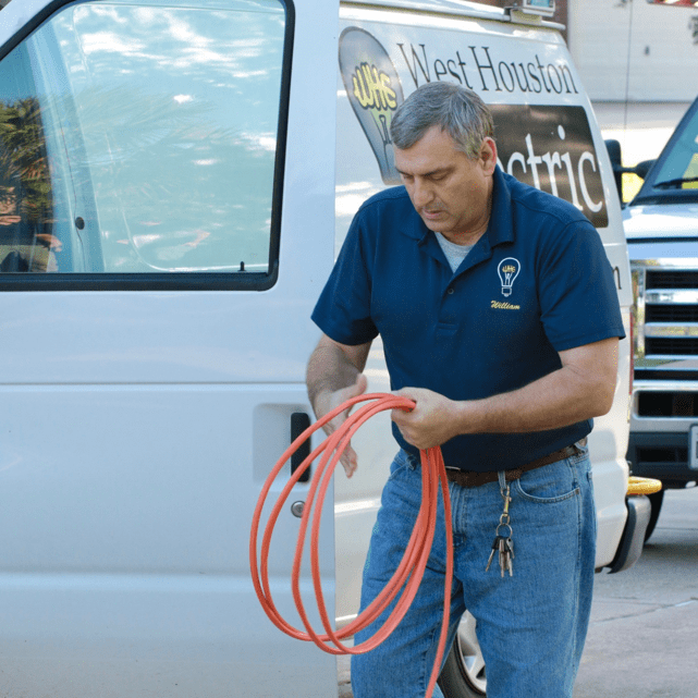 electrician gathering wires from service truck